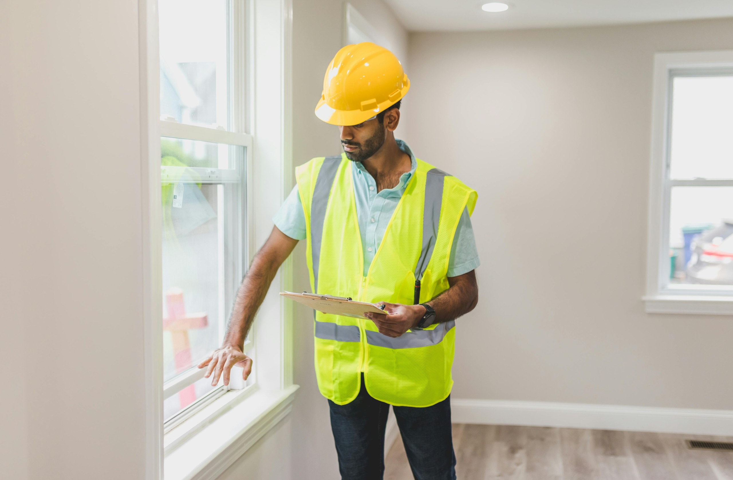General Contractors Manage During Home Construction Contractor inspecting window during construction.