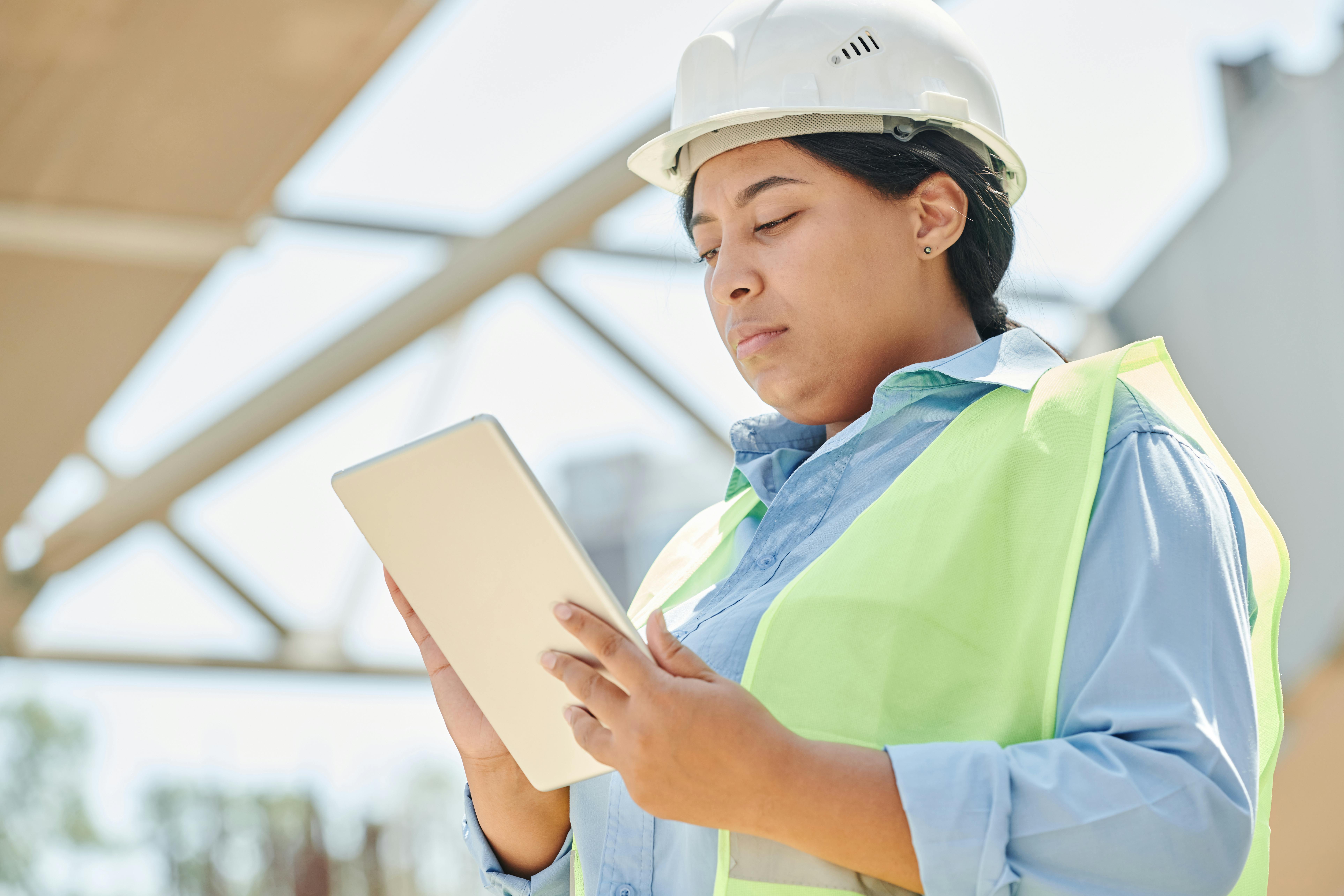 What to Ask a Seattle General Contractor Before a Major Renovation Construction worker using a tablet outdoors.